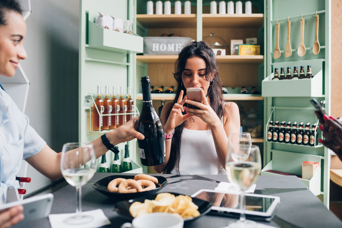 women looking up wine on her mobile device