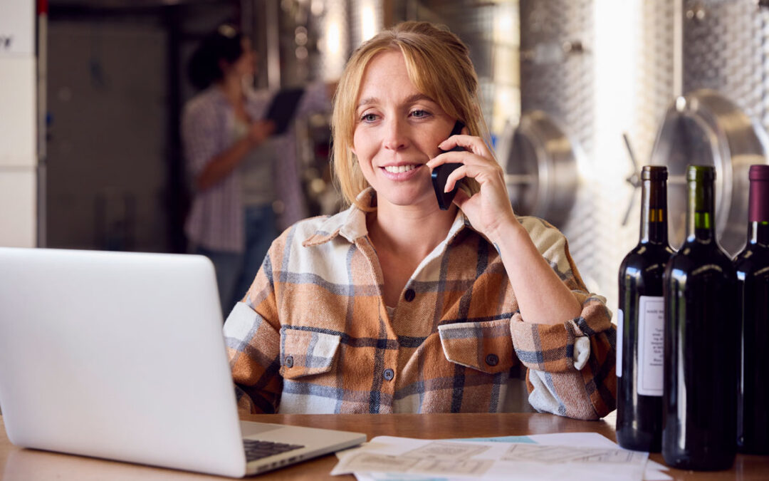 women on phone booking a reservation at a winery