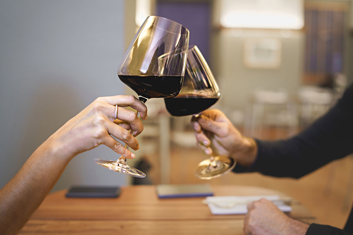 two people cheers two glasses of wine